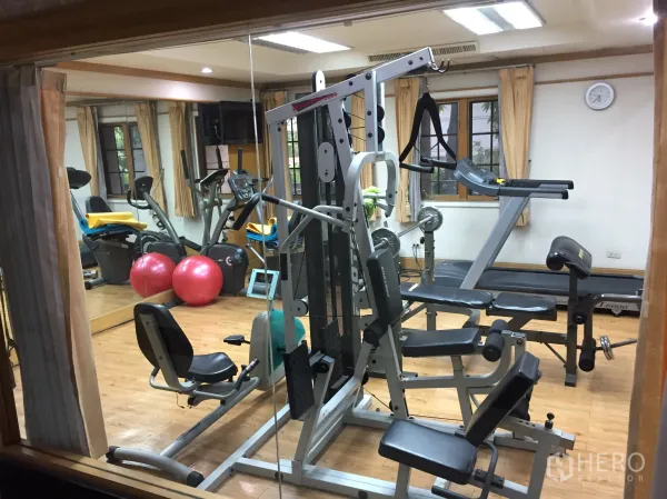 Condominium for rent in Khlong Toei, Bangkok - Condominium fitness room with strength machines, cardio equipment and mirrors.