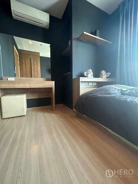 Condominium for sale in Phaya Thai, Bangkok - Secondary bedroom with dressing table, air‑conditioner, and floating shelves.