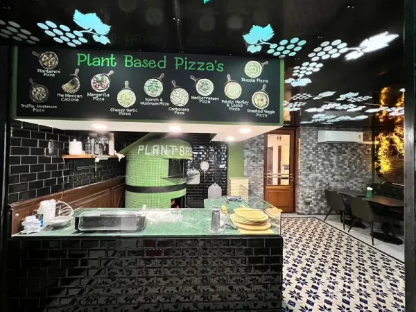 Shophouse for rent in Watthana, Bangkok - Open pizza station featuring a green-tiled oven, black subway tiles, and a menu board above the counter.