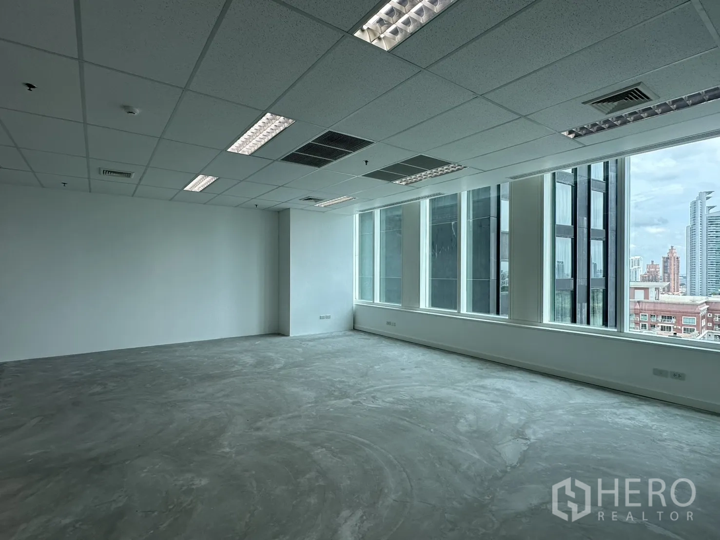 办公室 for rent in Watthana, Bangkok - 开放式办公室，整排大窗与吊顶灯具，远眺城市天际线。