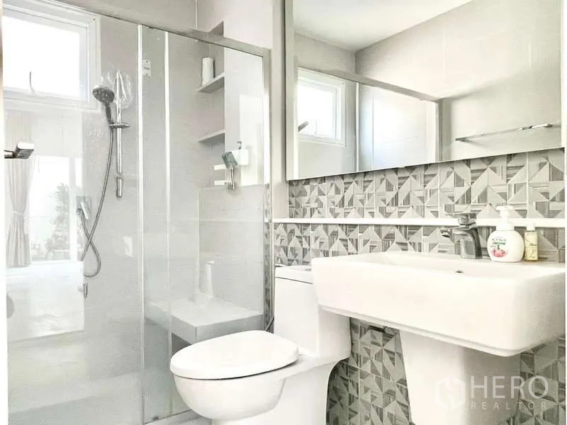 Detached House for rent in Prawet, Bangkok - Second bathroom featuring patterned backsplash, glass shower enclosure and window for ventilation.