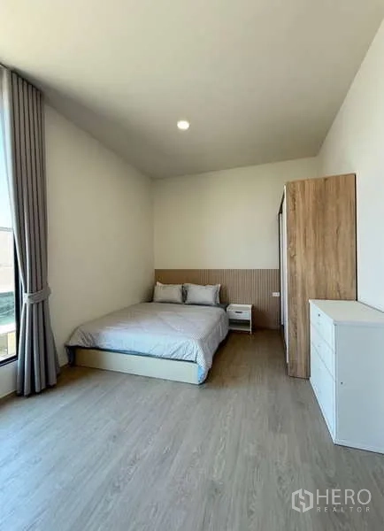 Townhouse for rent in Bang Phli, Samut Prakan - Spacious bedroom with double bed, wardrobe, dresser and floor-to-ceiling window.