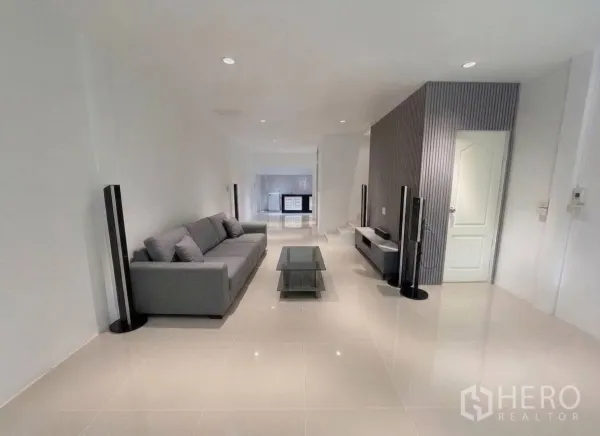 ทาวน์เฮาส์ for rent in Phra Khanong, Bangkok - ห้องนั่งเล่นสว่าง โซฟาสีเทา โต๊ะกลางกระจก และชั้นวางทีวี.
