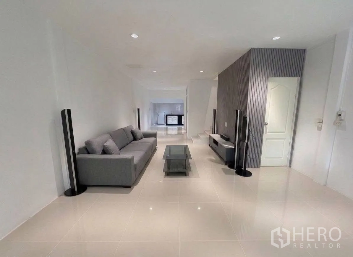 ทาวน์เฮาส์ for rent in Phra Khanong, Bangkok - ห้องนั่งเล่นสว่าง โซฟาสีเทา โต๊ะกลางกระจก และชั้นวางทีวี.