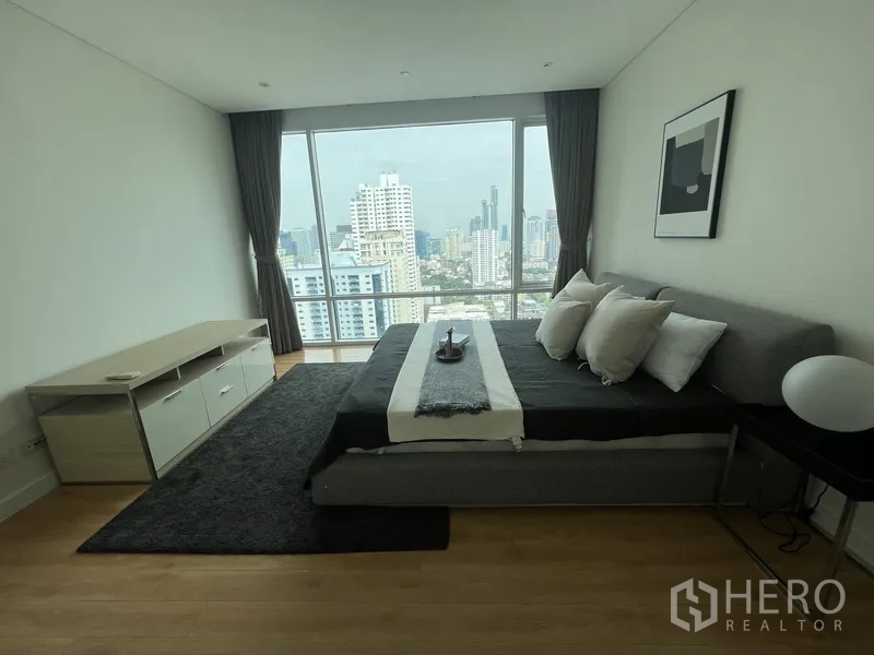 公寓 出租在Watthana, Bangkok - 主卧配特大床与整面窗，远眺城市景观。