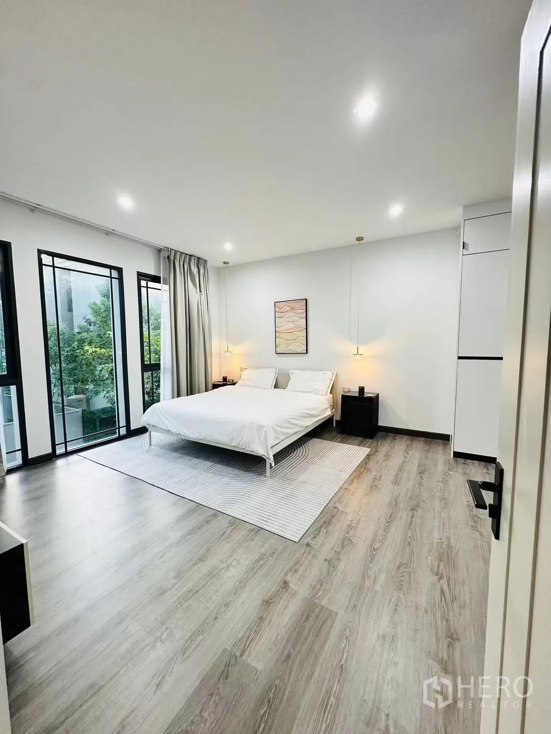 联排别墅 for rent in Suan Luang, Bangkok - 宽敞卧室，落地窗与木纹地板，装饰简约。