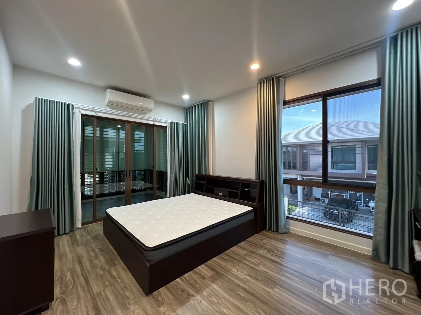Detached House for rent or sale in Bang Kapi, Bangkok - Primary bedroom with large windows and neighborhood view