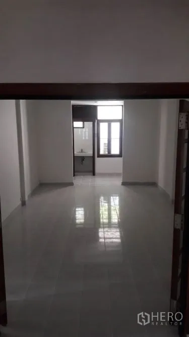 Detached House for rent in Yan Nawa, Bangkok - Long, bright room with glossy floor tiles leading to a small bathroom and window.