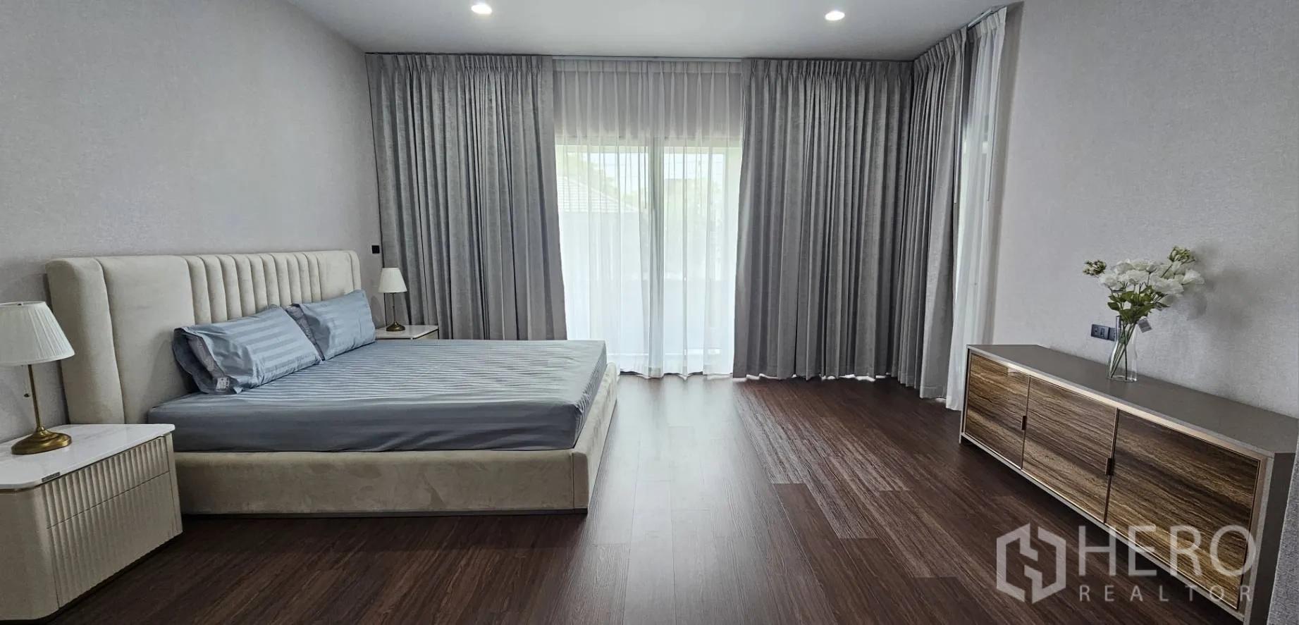 Detached House for rent in Bang Kapi, Bangkok - Spacious master suite with large windows and a sideboard.
