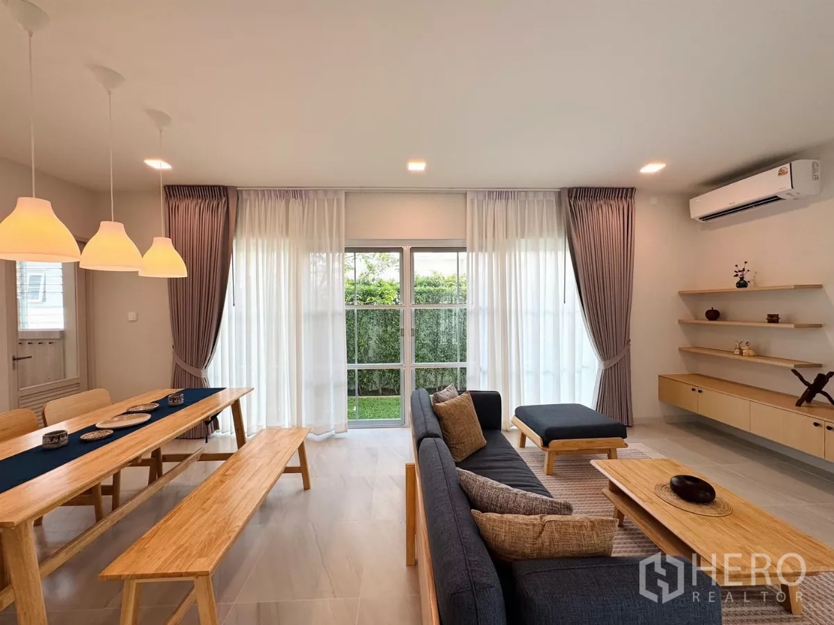 独立式住宅 出租在Bang Phli, Samut Prakan - 餐区紧邻推拉门通往草坪，与起居区相连