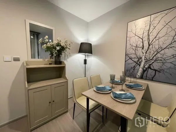 Condominium for rent in Chatuchak, Bangkok - Cozy dining corner with wall art, sideboard and floor lamp in neutral tones.