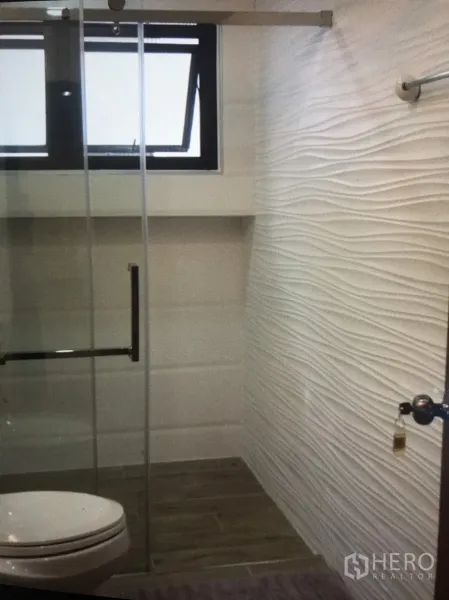 Condominium for rent in Bang Rak, Bangkok - Modern bathroom featuring a glass-enclosed shower, textured white wall tiles and a window.