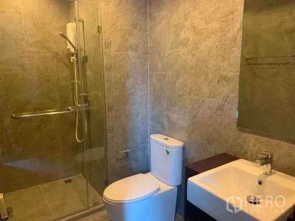 คอนโด ให้เช่าในWatthana, Bangkok - ห้องน้ำสมัยใหม่พร้อมตู้กระจกกั้นอาบน้ำ โถสุขภัณฑ์ และอ่างล้างหน้าแบบสี่เหลี่ยม.