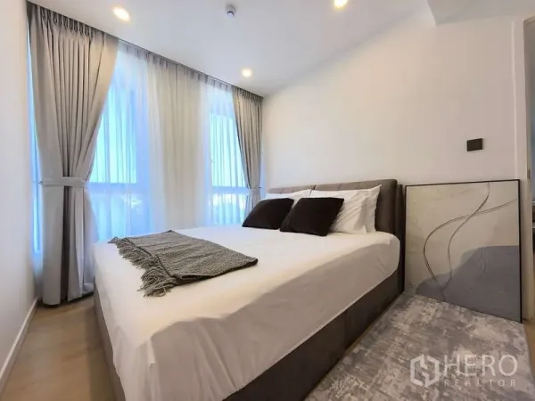 Apartment for rent - Cozy bedroom with double bed, floor-to-ceiling windows and grey blackout curtains.