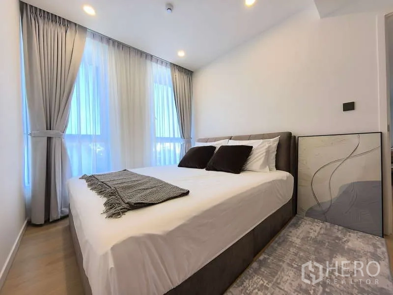 Apartment for rent - Cozy bedroom with double bed, floor-to-ceiling windows and grey blackout curtains.