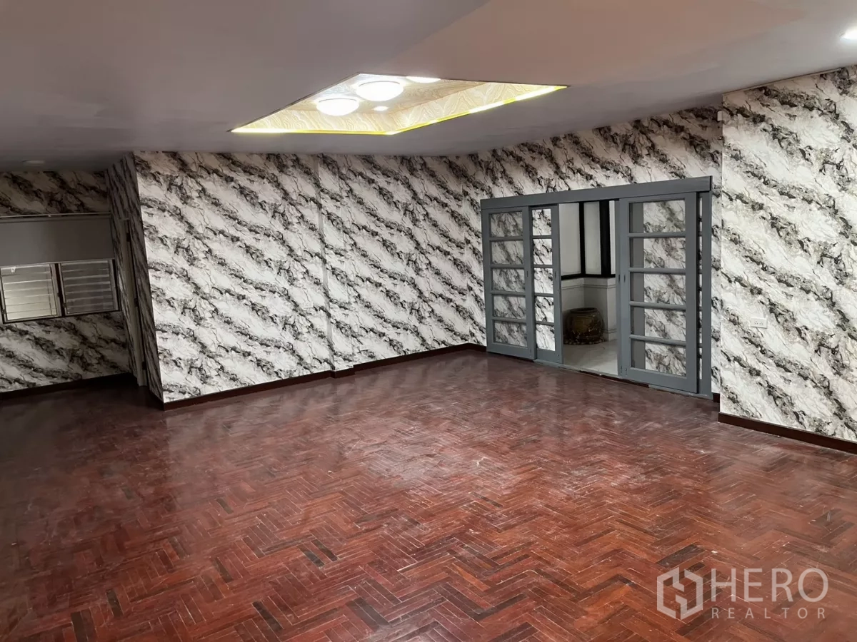 Detached House for rent in Watthana, Bangkok - Grand lounge with patterned feature walls, recessed ceiling lights and sliding glass doors.