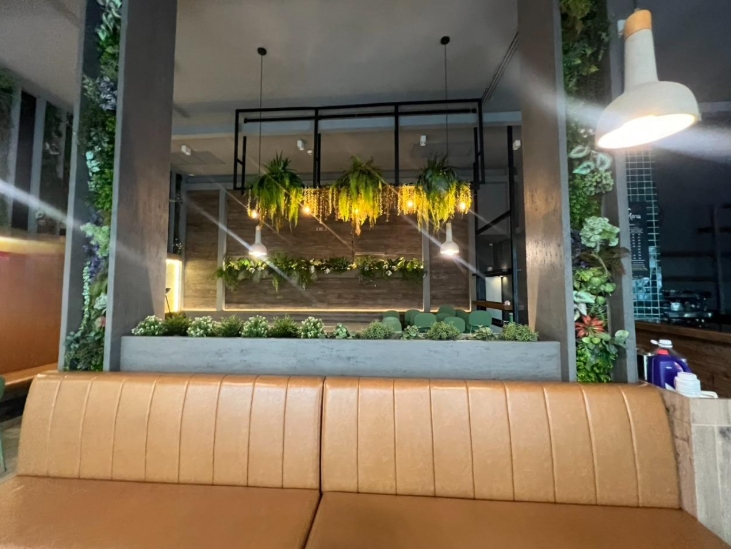 พื้นที่ขายปลีก ให้เช่าในWatthana, Bangkok - ภายในร้านสมัยใหม่ มีเบาะหนังสีน้ำตาล โคมไฟห้อย และสวนแนวตั้งตกแต่งด้วยต้นไม้
