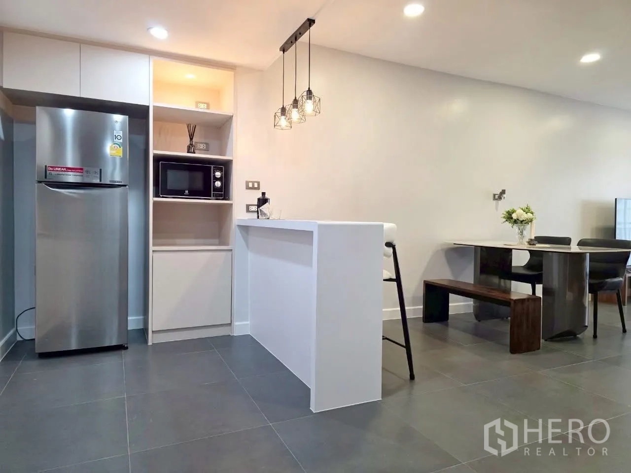 Condominium for rent in Sathon, Bangkok - Open kitchen with breakfast bar, pendant lights and dining bench.