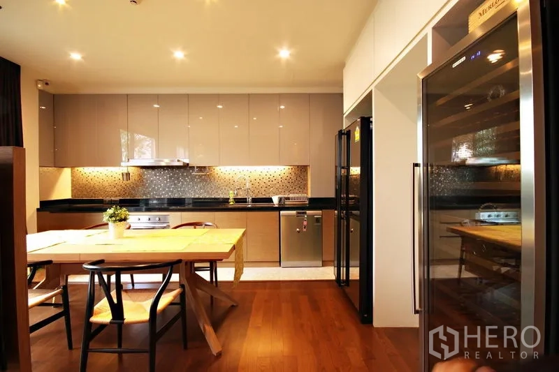 Condominium for rent or sale in Khlong Toei, Bangkok - Kitchen and dining facing double refrigerators and a wine cooler in warm wood tones.