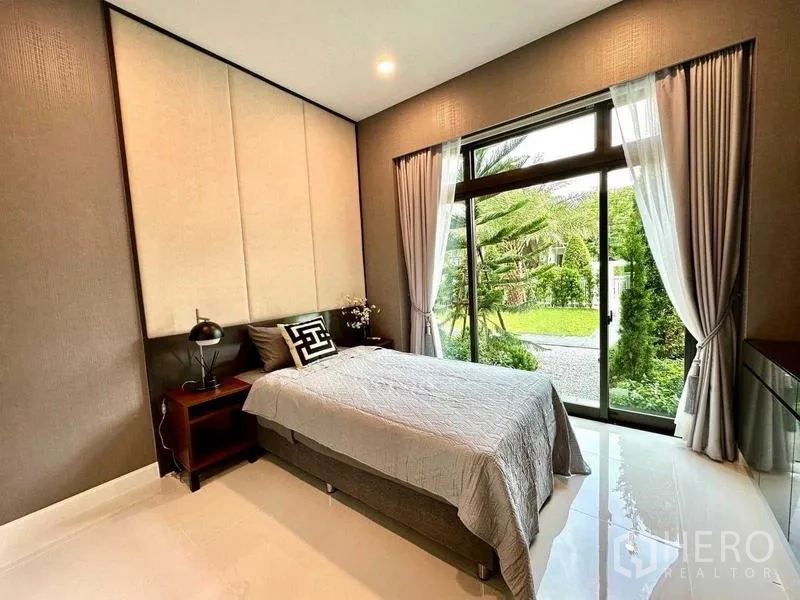 独立式住宅 出租在Bang Phli, Samut Prakan - 卧室配落地窗，眺望修景花园。