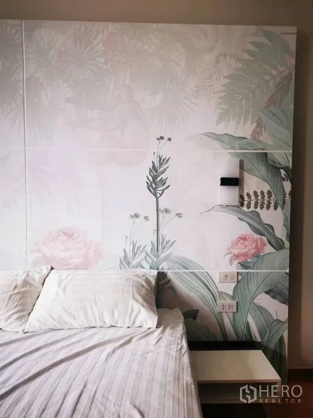 Condominium for sale in Khlong Toei, Bangkok - Close-up of headboard wall with botanical mural and a bedside table.