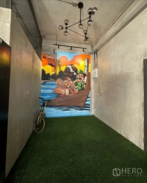 Retail Space for rent in Watthana, Bangkok - Narrow interior corridor with artificial turf and modern ceiling lights leading to a bright wall mural.