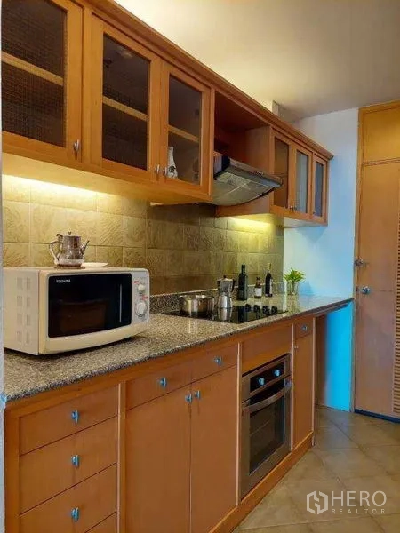 Apartment for rent - Cooking zone with built-in hob, oven, microwave and under-cabinet lighting.