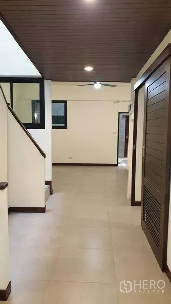 联排别墅 出租或出售在Khlong Toei, Bangkok - 走廊配木质天花与楼梯通往二层。