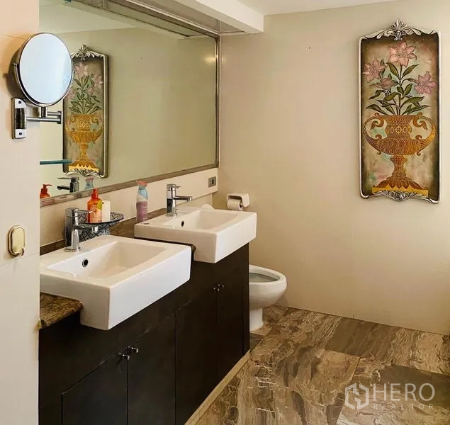 Condominium for rent in Khlong Toei, Bangkok - Bathroom with twin square basins, large mirror and marble-look flooring.