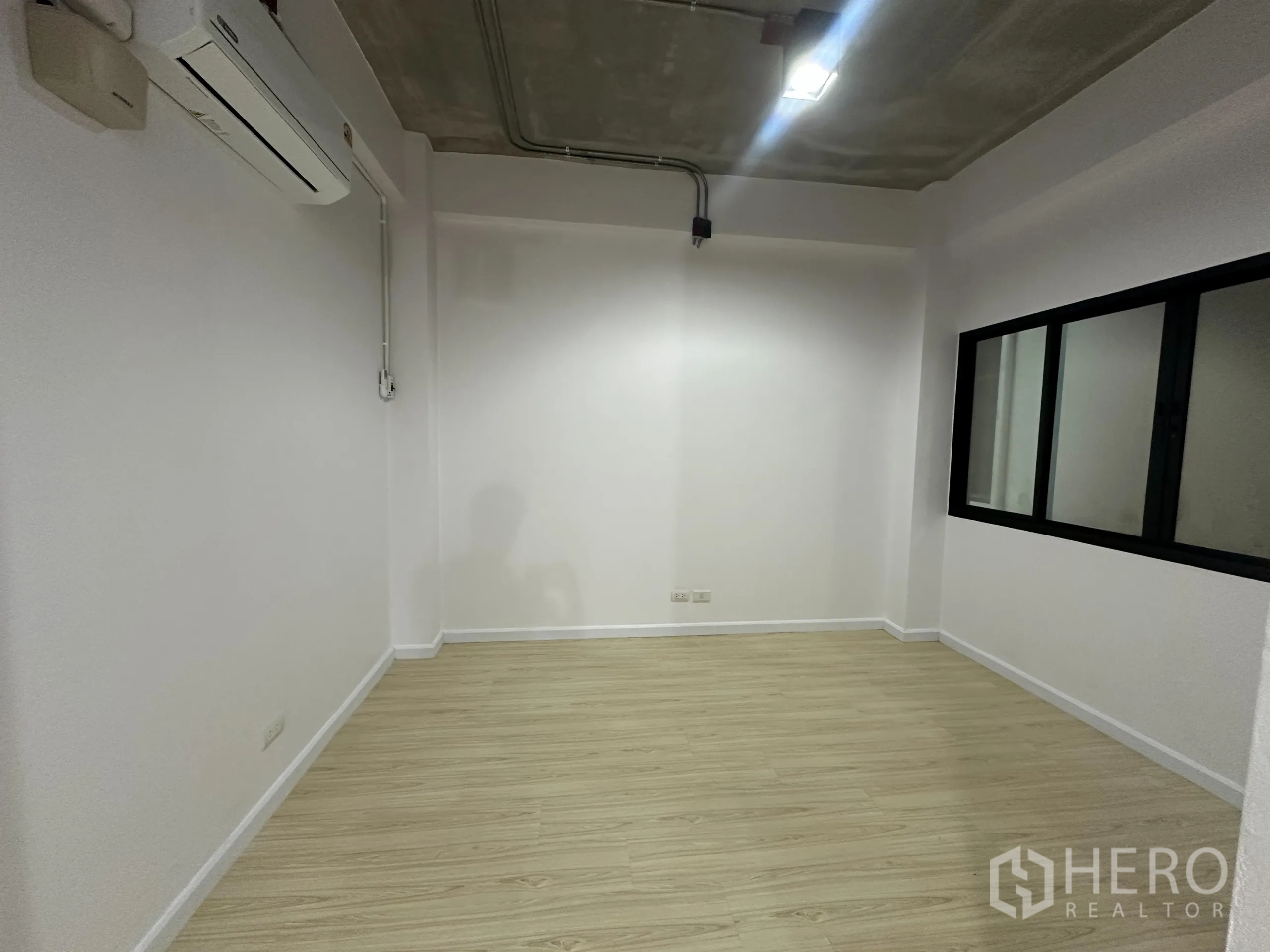办公空间 出租在Watthana, Bangkok - 私密会议室，带窗户、分体空调与木纹地板。