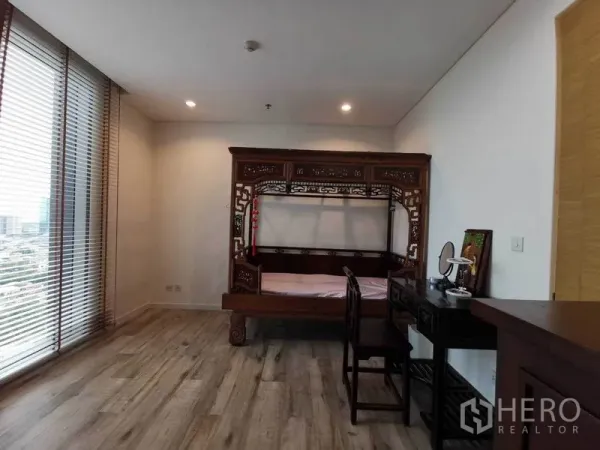 公寓 出租或出售在Bang Rak, Bangkok - 采光充足的卧室，落地窗与木地板，配精美雕花木床与书桌。