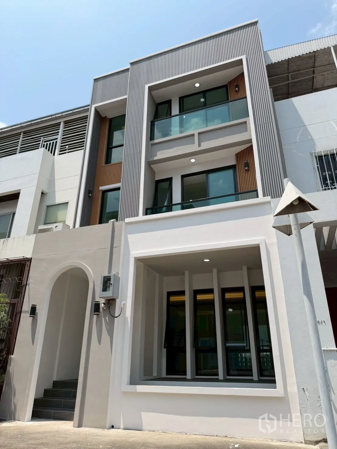 Townhouse for sale in Phra Khanong, Bangkok - Contemporary townhouse facade with balconies and large windows.