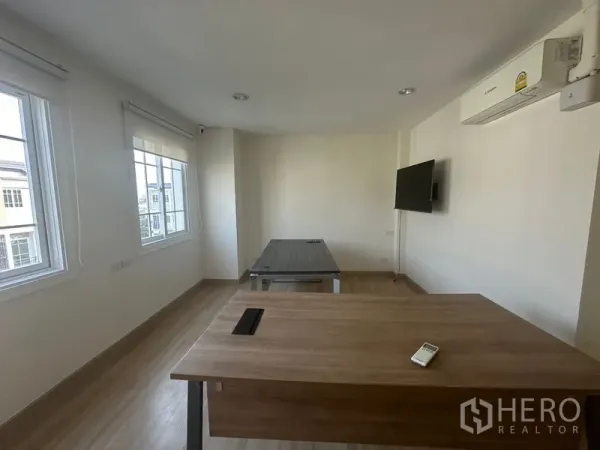 Home Office for rent in Bang Na, Bangkok - Office room with desks, wall-mounted TV, air conditioning and multiple windows.