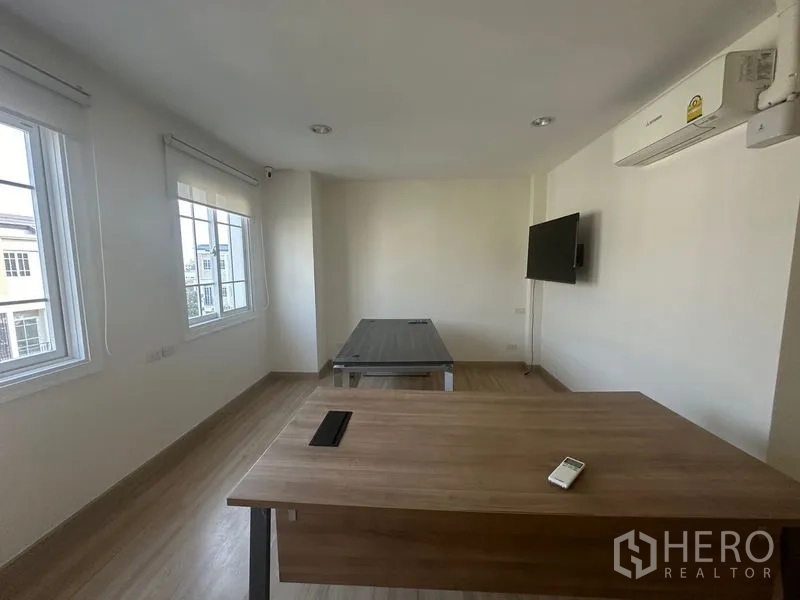 Home Office for rent in Bang Na, Bangkok - Office room with desks, wall-mounted TV, air conditioning and multiple windows.