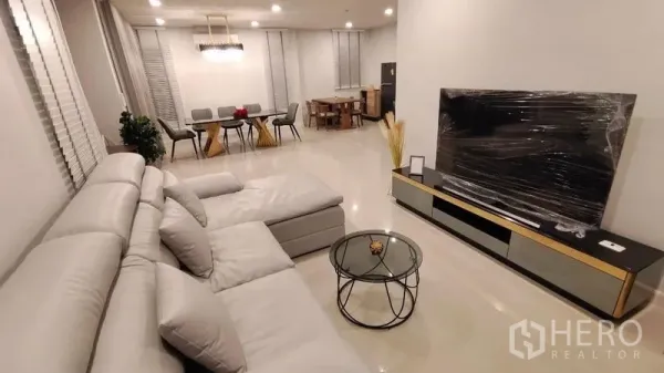 独立式住宅 出租在Prawet, Bangkok - 开放式客厅，灰色转角沙发、电视柜与茶几