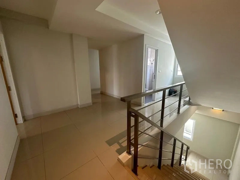 Home Office for rent in Bang Na, Bangkok - Stair landing with metal handrail and access to a bathroom.