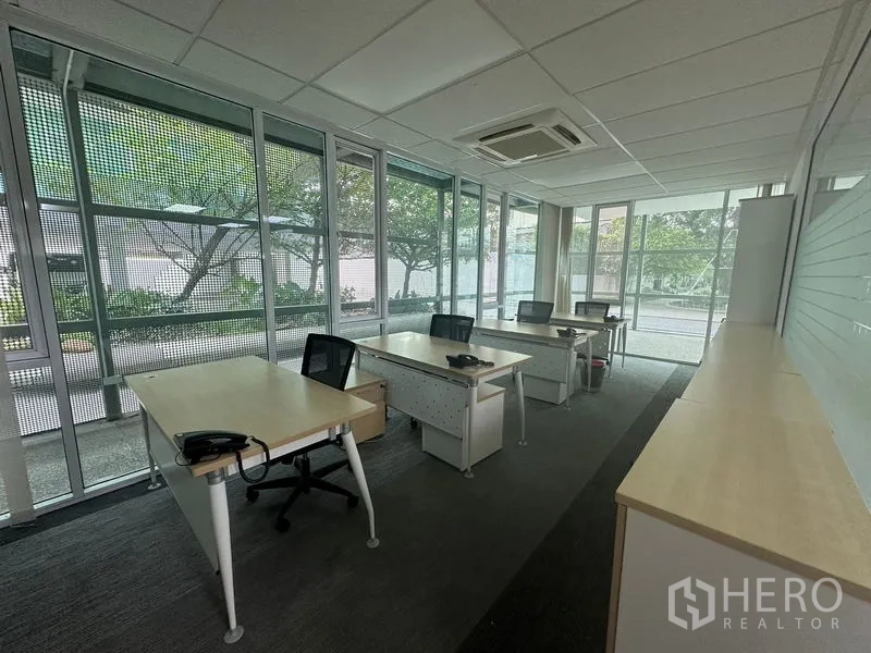 办公空间 出租 - 三面临窗工作区，多张办公桌，花园景观与地毯地面。