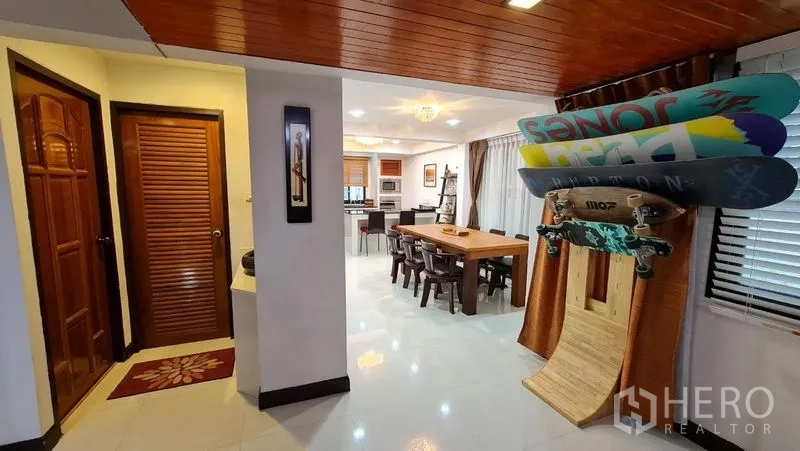 Detached House for rent in Saphan Sung, Bangkok - Hallway to the kitchen with wood ceiling and storage, next to a guest bathroom.