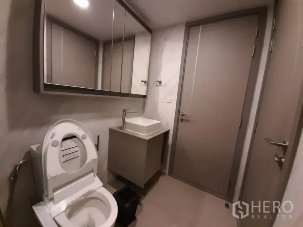 公寓 出租或出售在Watthana, Bangkok - 紧凑卫浴，镜面柜、方形台盆与坐便器。