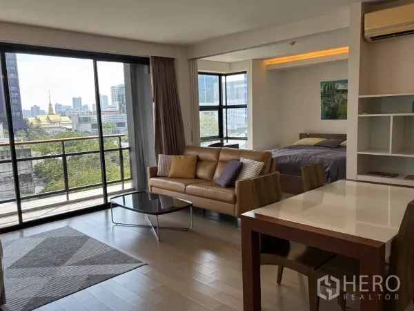 Condominium for sale in Watthana, Bangkok - Bright open-plan living room with floor-to-ceiling windows, balcony, and city view near Ekkamai.