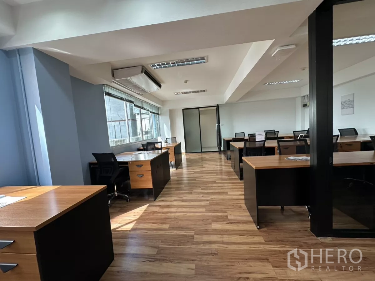 办公空间 出租在Watthana, Bangkok - 明亮的开放式办公室，成排木质桌子和宽大的窗户。