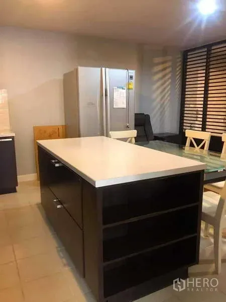 Condominium for sale in Yan Nawa, Bangkok - Modern kitchen with a large white island, stainless double-door fridge and tiled floor.