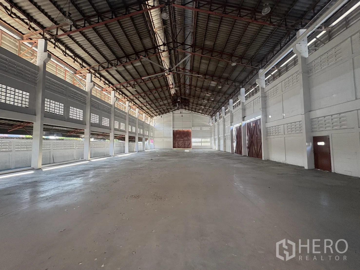 货栈 出租在Bang Phli, Samut Prakan - 宽敞仓库内部，高钢桁架屋顶与混凝土地面。