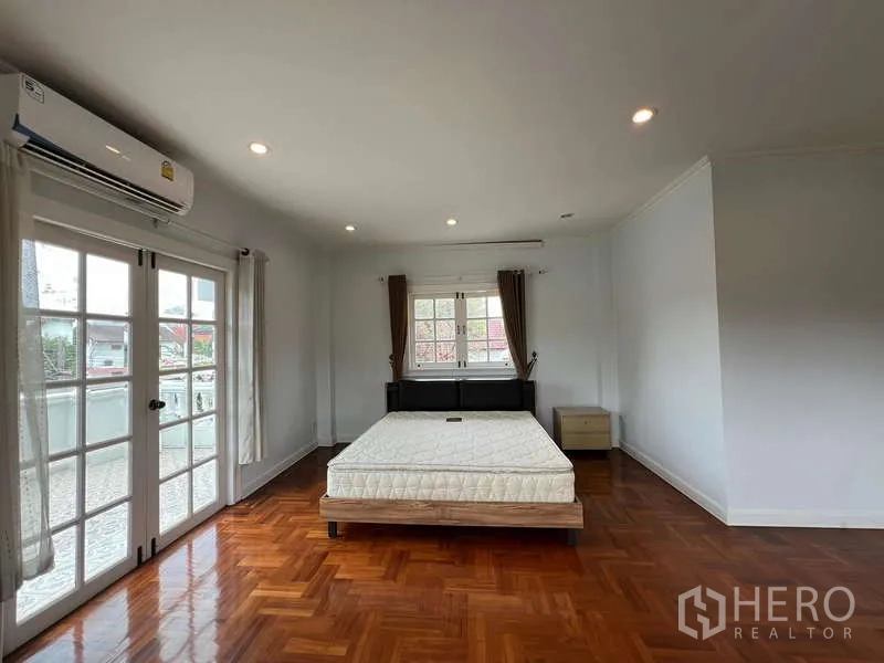 Detached House for rent in Bang Phli, Samut Prakan - Another spacious bedroom with windows on two sides and polished wood floor.