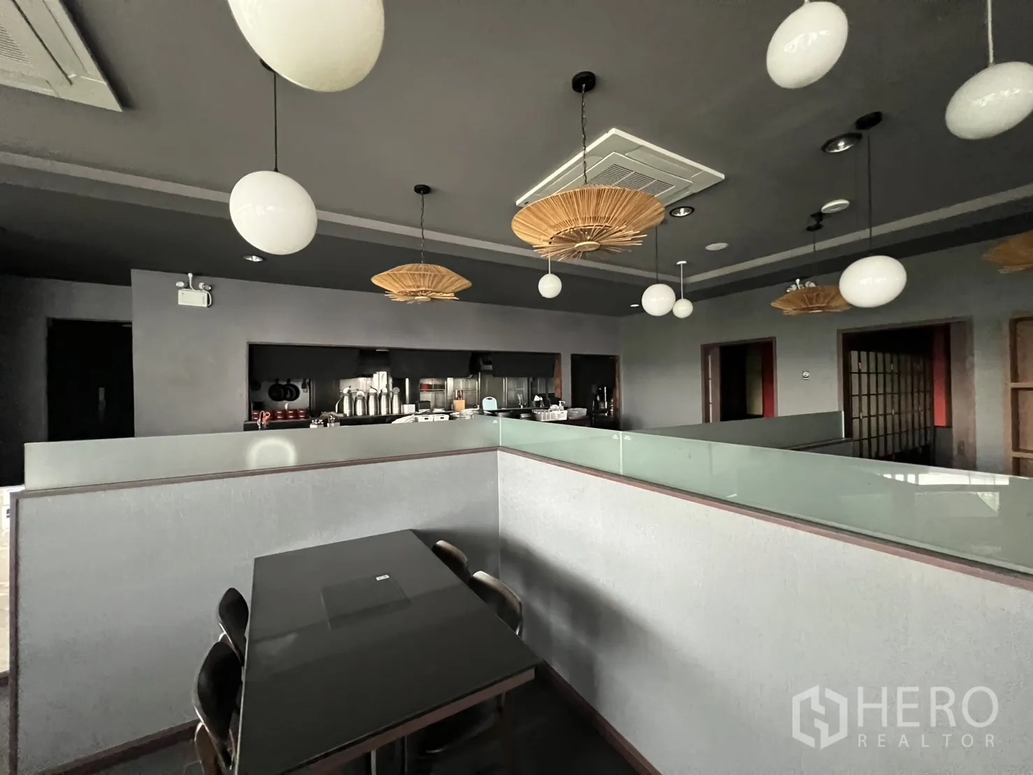 พื้นที่ขายปลีก for rent in Watthana, Bangkok - เคาน์เตอร์ครัวแบบเปิดพร้อมโคมไฟทรงกลม เพดานโทนเข้ม และที่นั่งในพื้นที่ค้าปลีกตกแต่งพร้อมใช้งาน