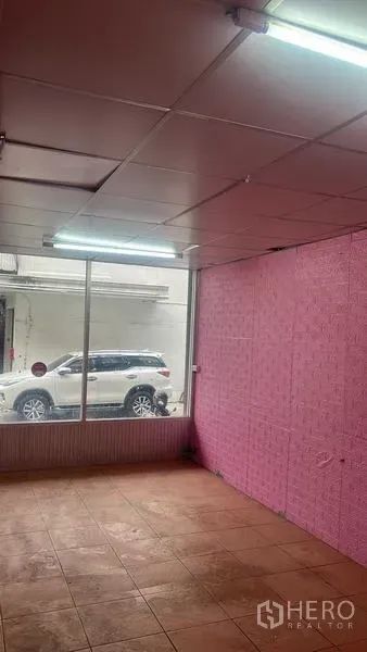 零售空间 出租在Bang Na, Bangkok - 店内展示区，临街落地窗、瓷砖地面与荧光灯顶灯。