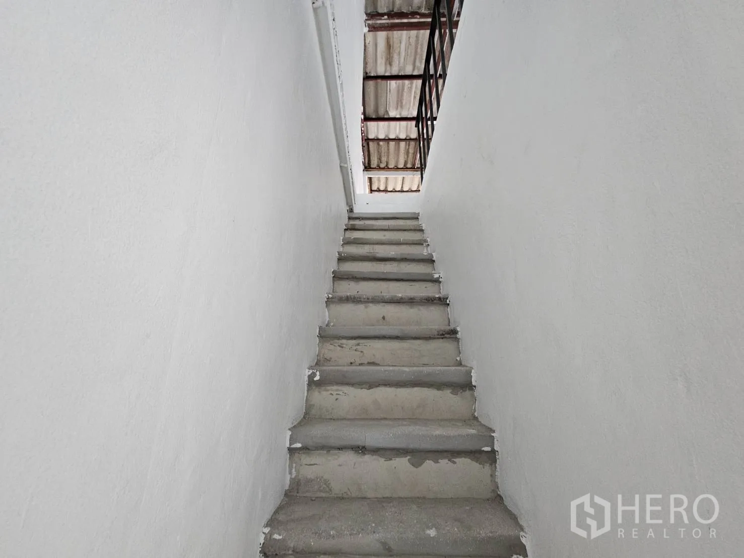Home Office for rent in Khlong Toei, Bangkok - Concrete stairwell ascending to the upper floors with a metal handrail.