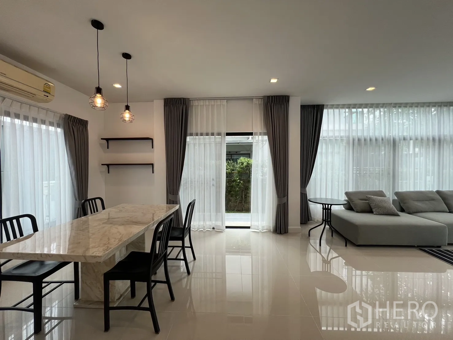 Detached House for rent in Bang Kapi, Bangkok - Dining and living corner with pendant lights and full-height windows.