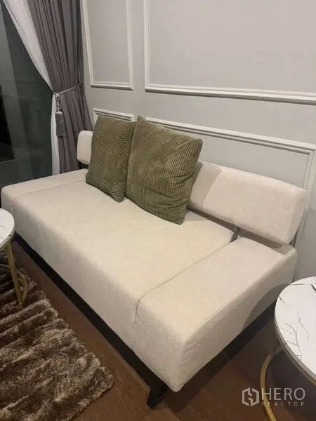 公寓 出租在Khlong Toei, Bangkok - 米色沙发特写，搭配抱枕与落地窗帘。