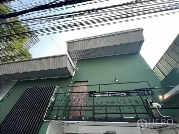 零售空间 出租在Watthana, Bangkok - 通罗区域绿色立面街景视角，带阳台和金属雨棚。